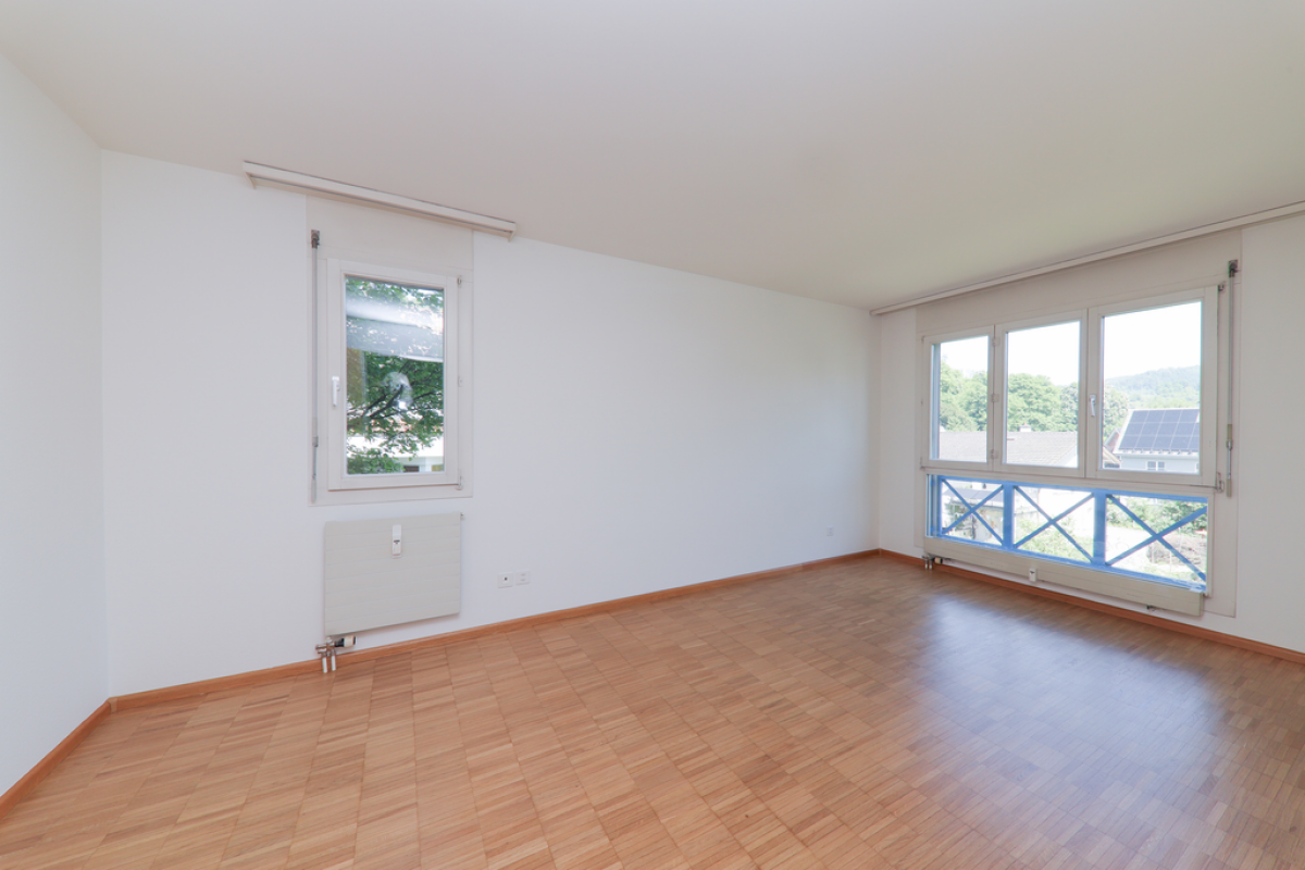 Helles, leeres Zimmer mit großen Fenstern