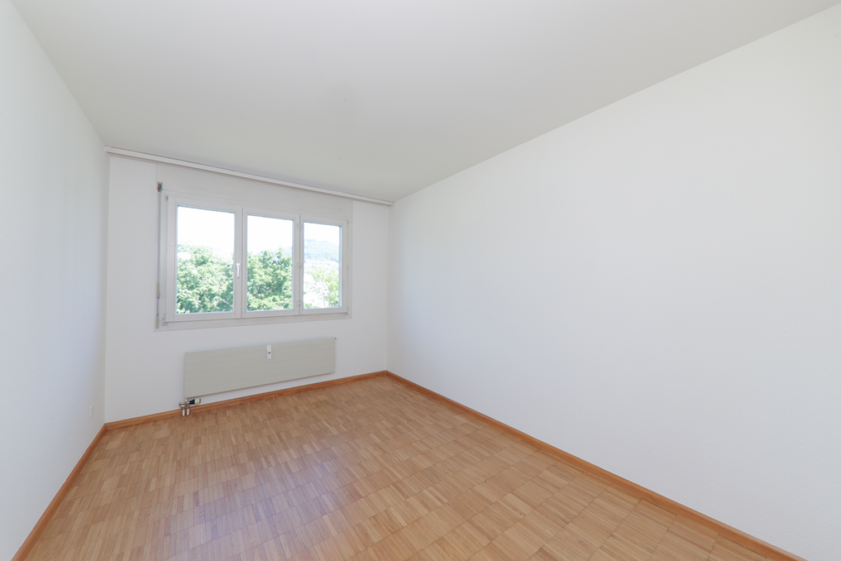 Leerer heller Raum mit Fenster und Heizkörper