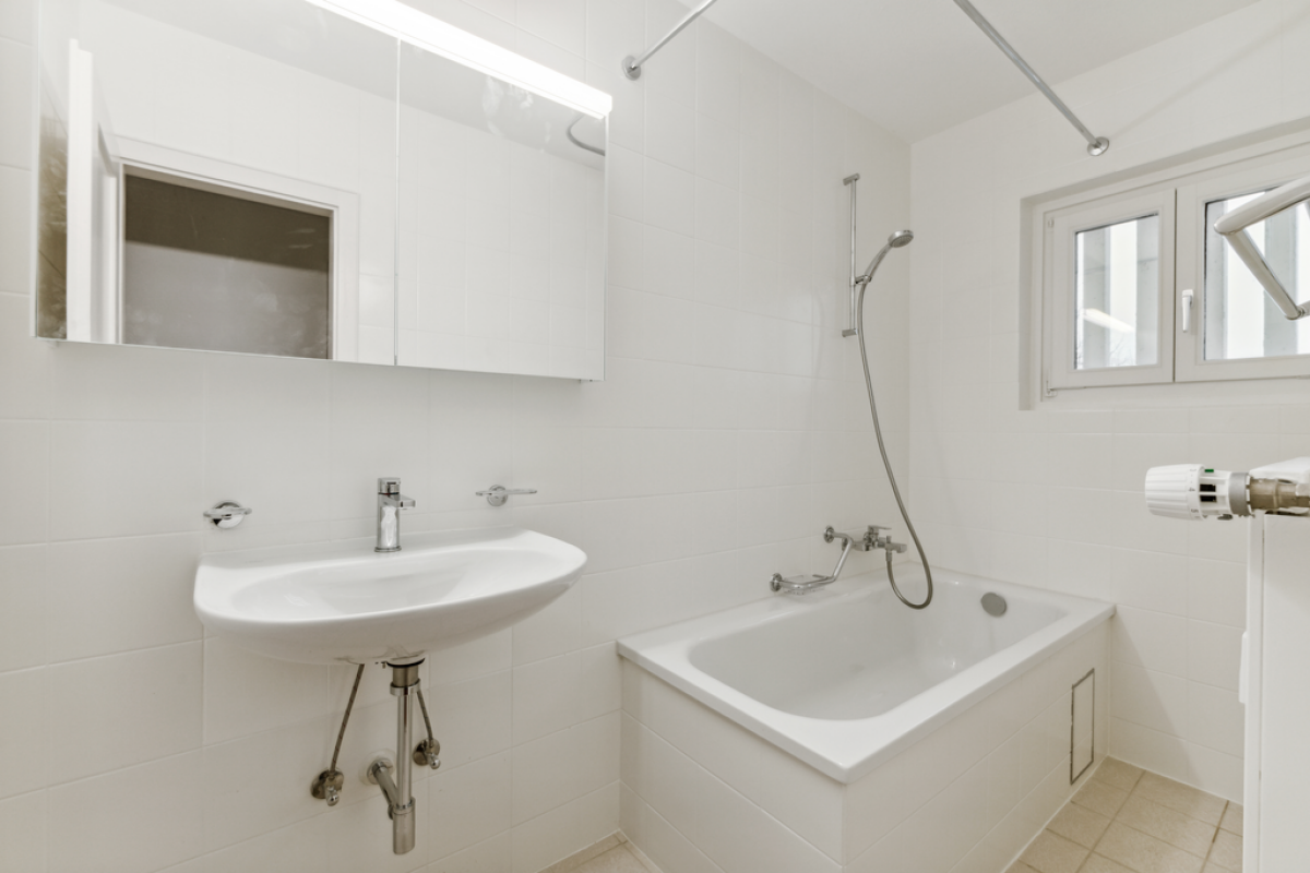 Helles Badezimmer mit Badewanne und Wandwaschbecken