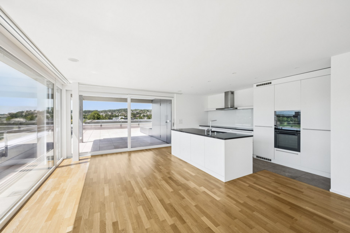 Offener Wohnbereich mit moderner Küche und großer Terrasse