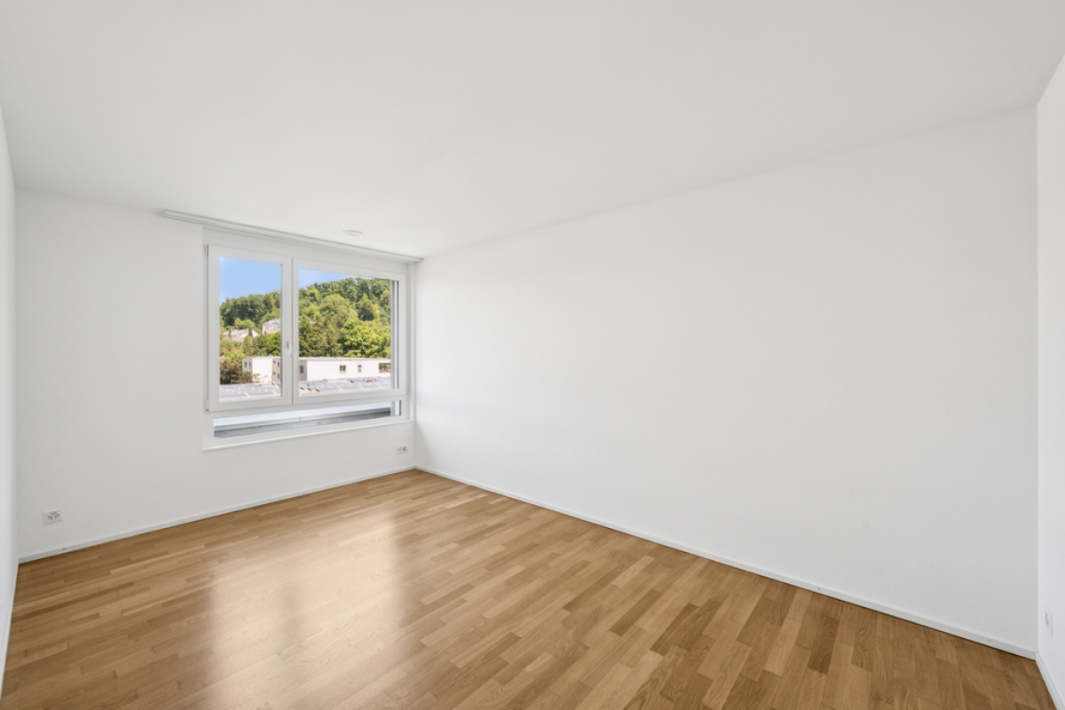 Heller leerer Raum mit Parkettboden und Fenster