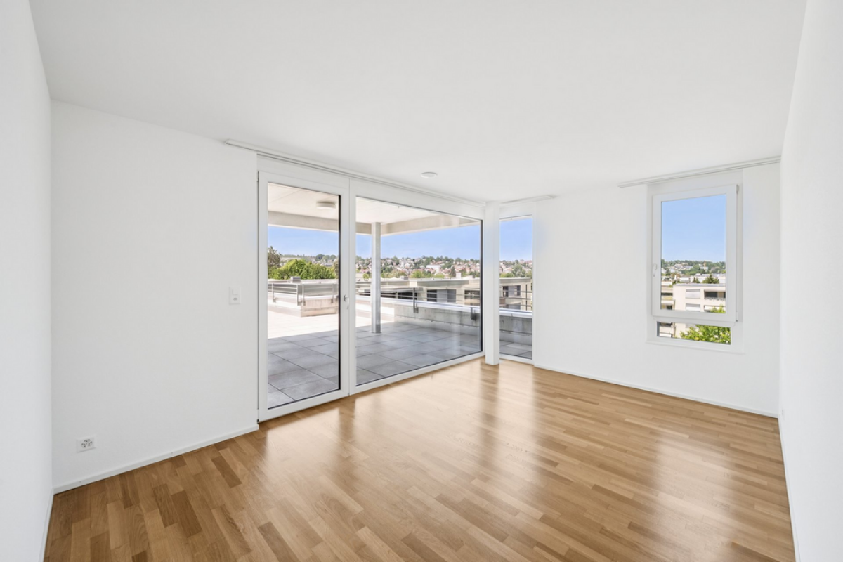 Heller leerer Wohnraum mit Terrasse und Ausblick