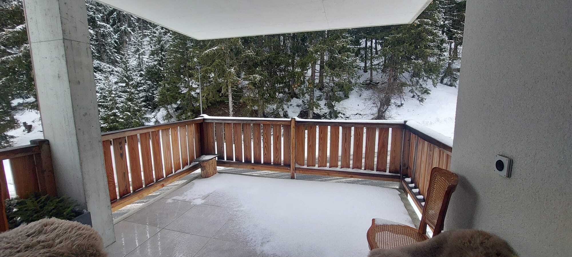 Schneebedeckte Terrasse mit Waldblick