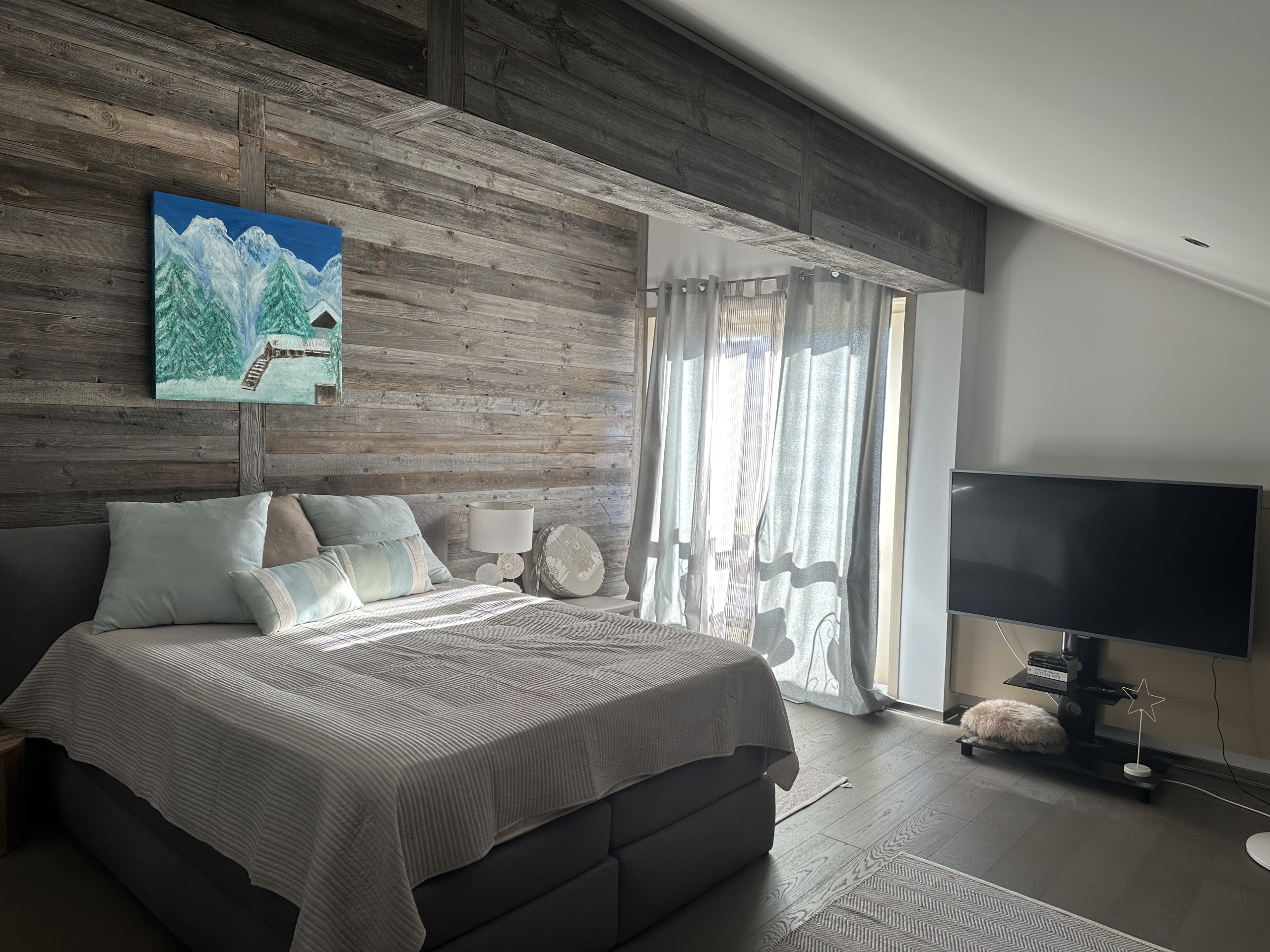 Gemütliches Schlafzimmer mit rustikaler Holz-Akzentwand