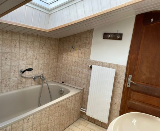 Badezimmer mit Wanne und Holz­tür