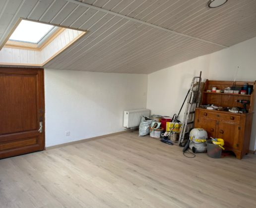 Heller ausgebauter Dachraum mit Holzschrank und Werkzeugen