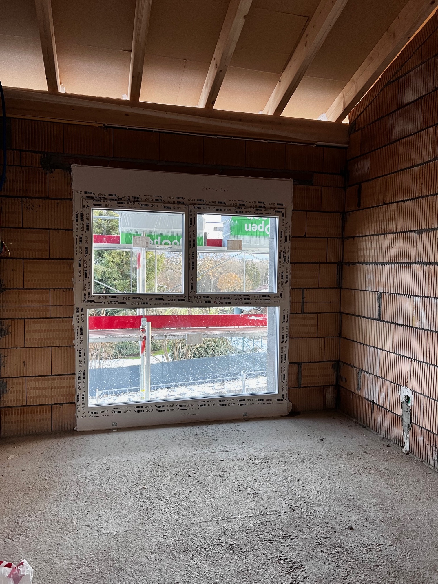 Innenraum im Rohbau mit großem Fenster