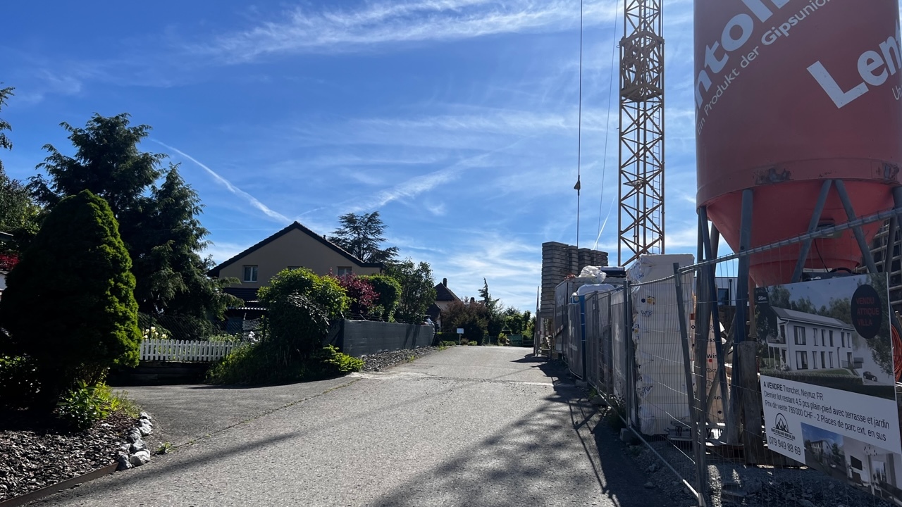 Straßenansicht mit Baustelle neben Wohnhäusern