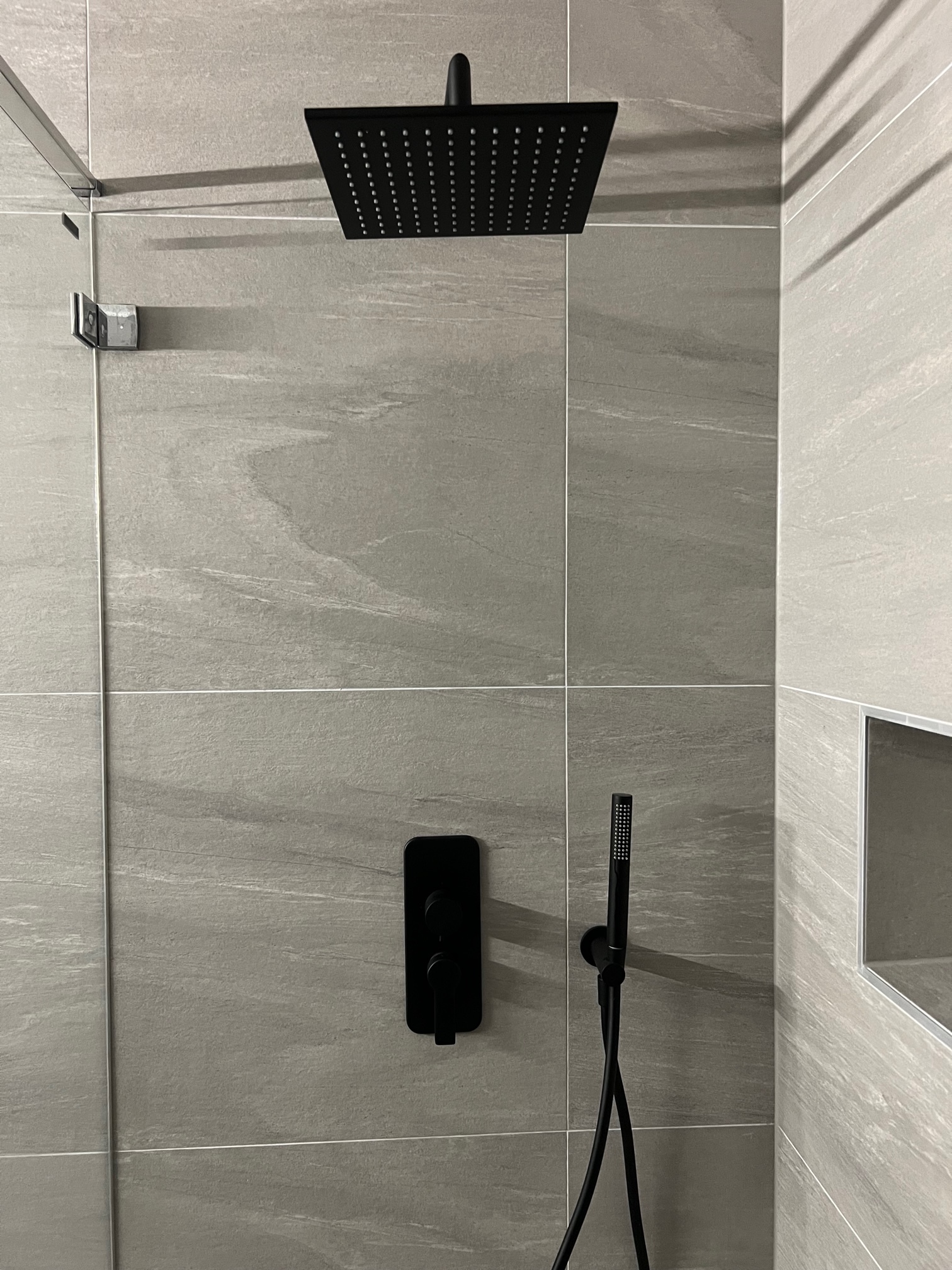 Moderne Dusche mit dunkler Armatur