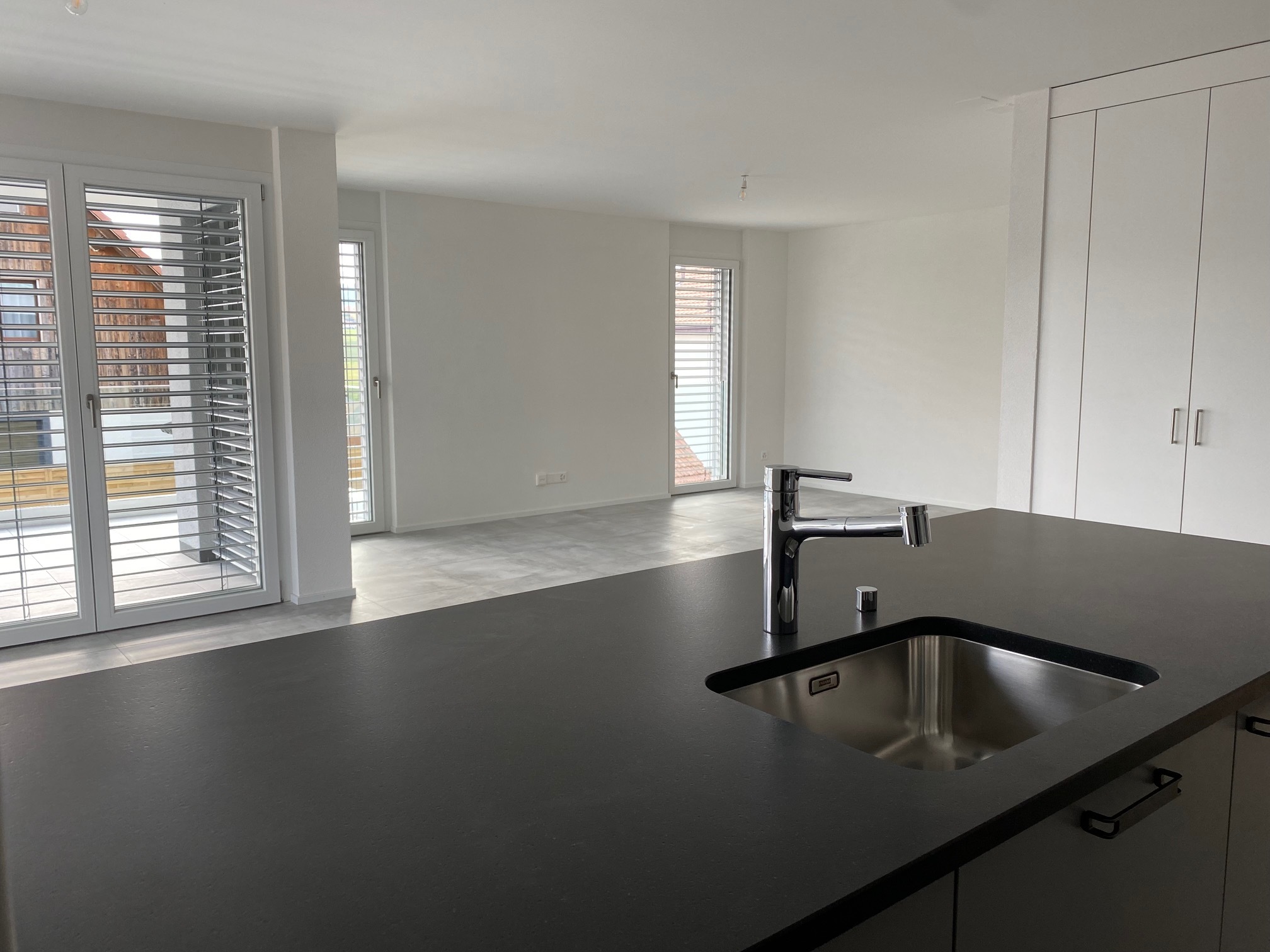 Moderne, helle Küche mit Blick in einen offenen Wohnbereich