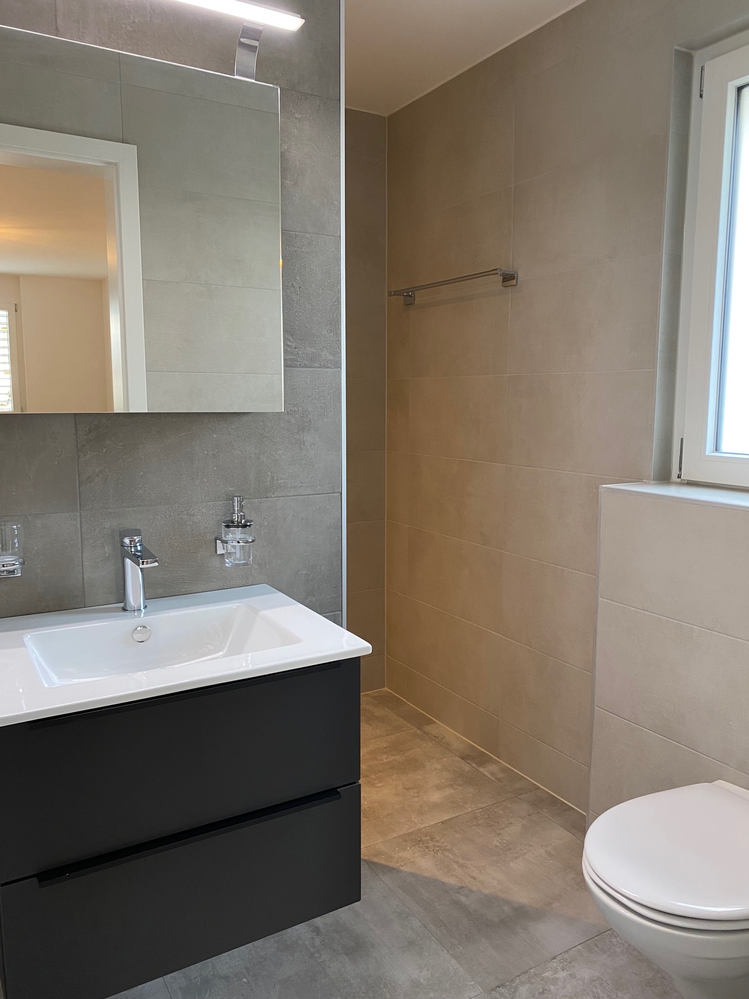 Modernes Badezimmer mit Waschbecken, Dusche und WC