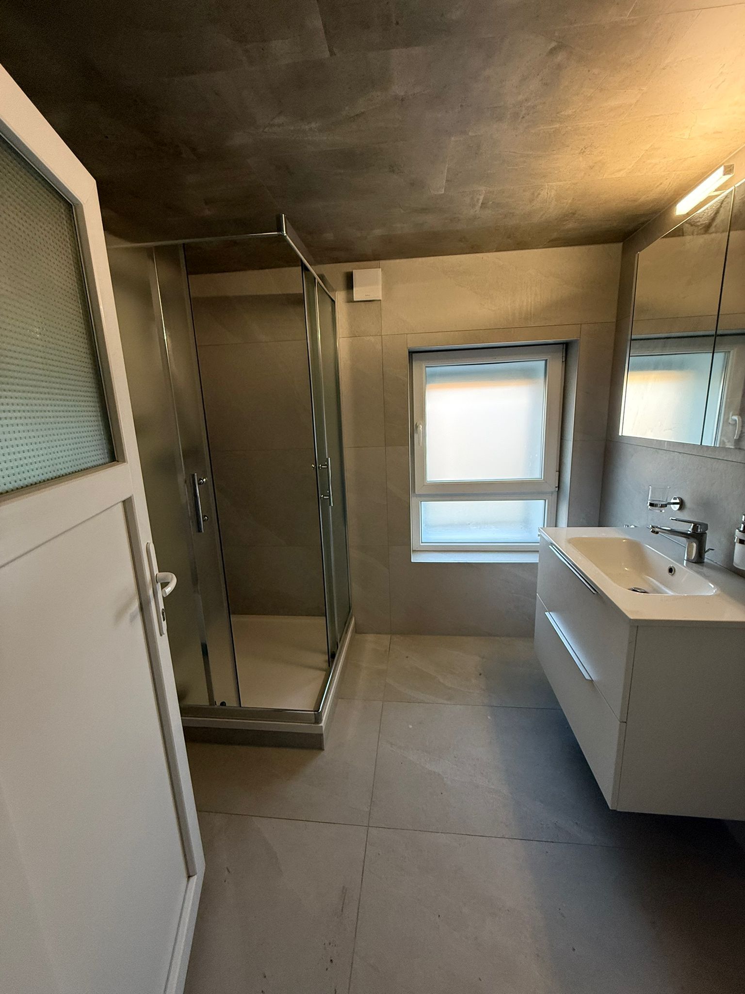Modernes Bad mit Dusche und Waschtisch