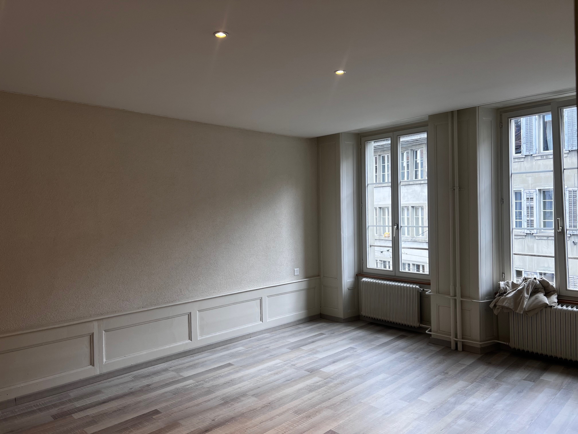 Leerer Altbau-Raum mit großen Fenstern