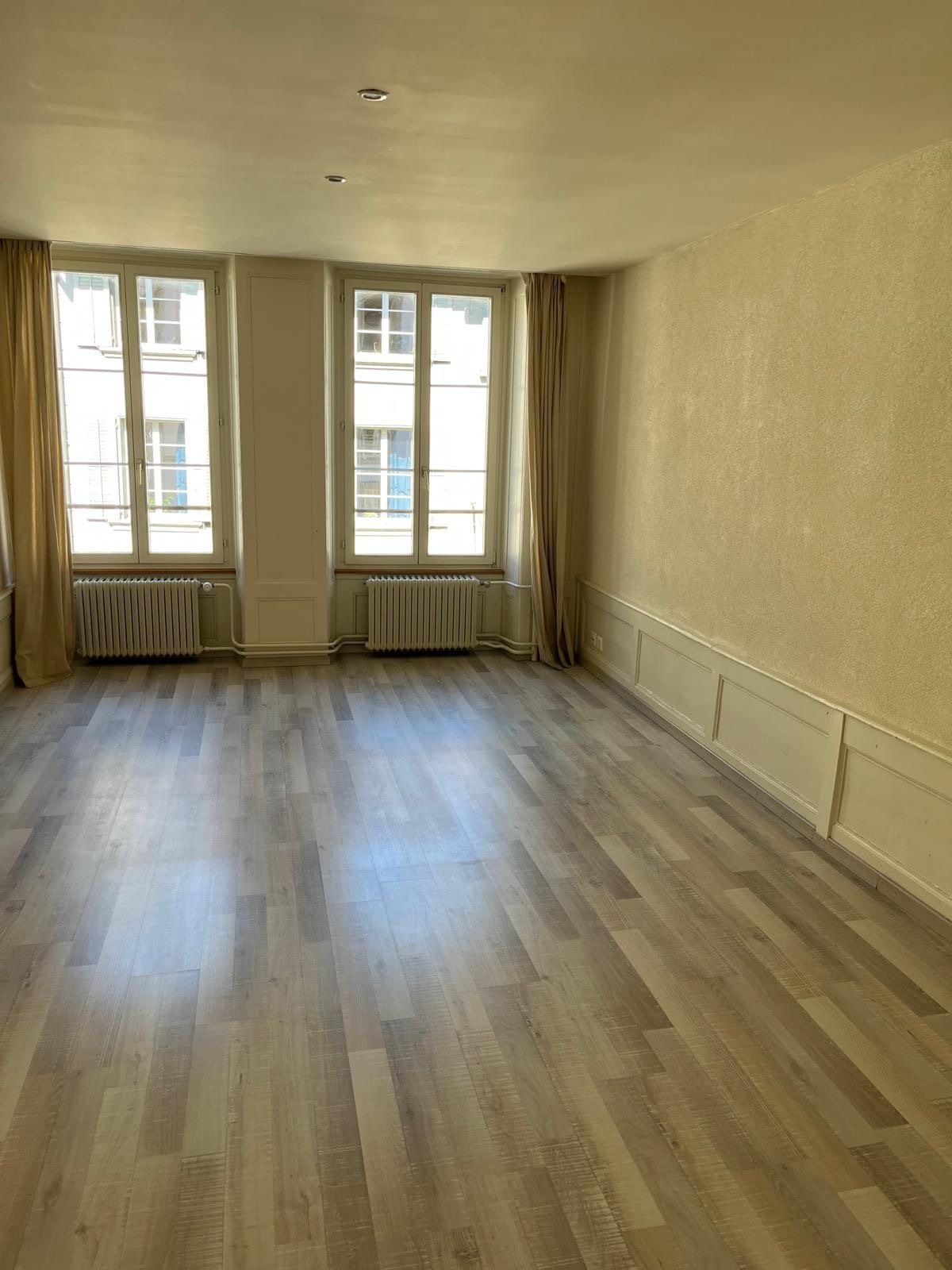 Heller leerer Wohnraum mit hohen Fenstern