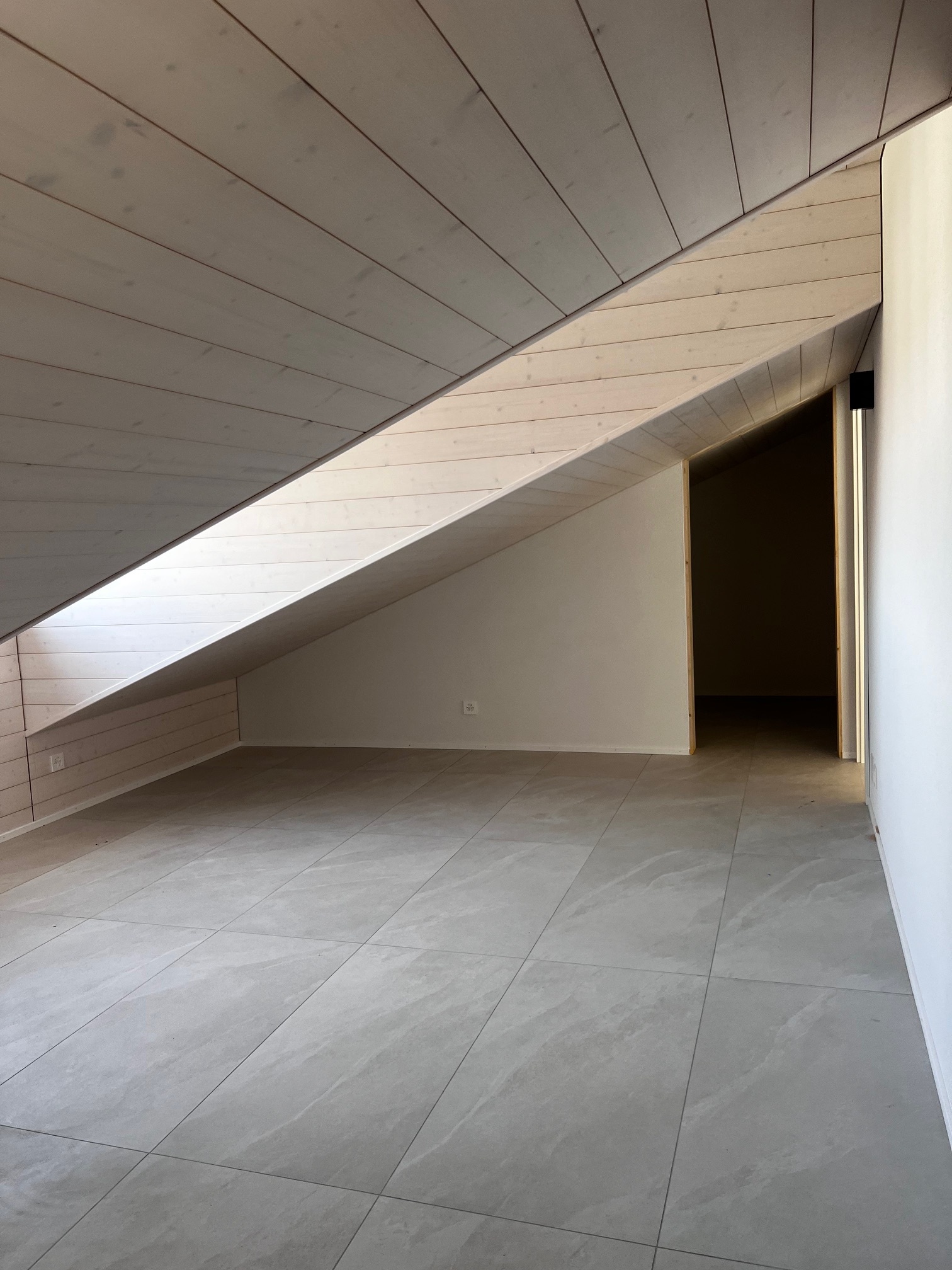Dachgeschossraum mit schräger Holzdecke