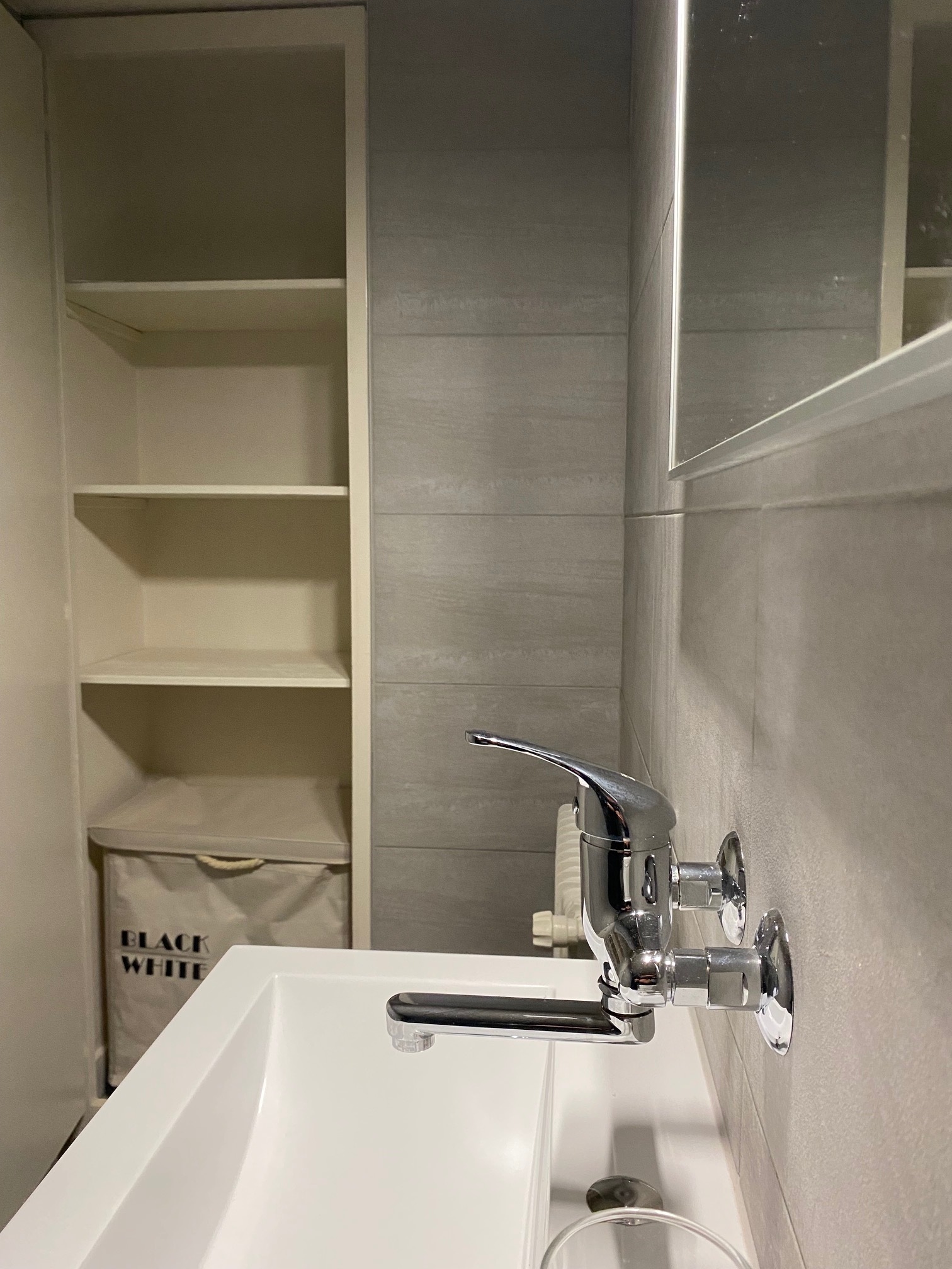 Modernes kleines Bad mit Waschbecken und Einbauregal