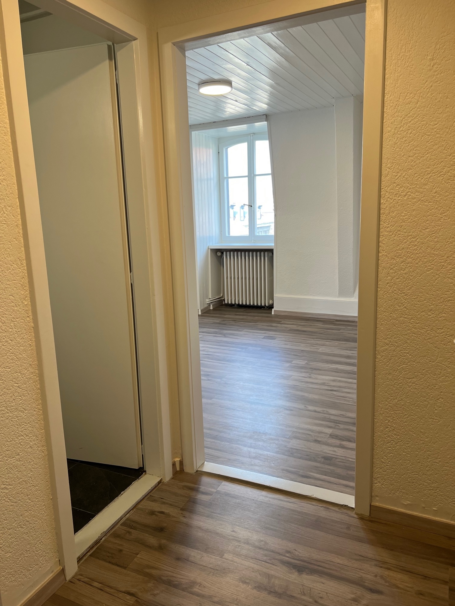 Heller Flur mit Durchgang zu einem Zimmer