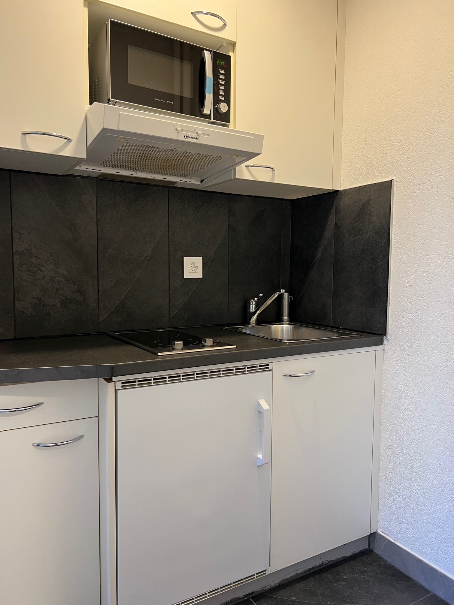 Kompakte Küchenzeile mit dunkler Rückwand