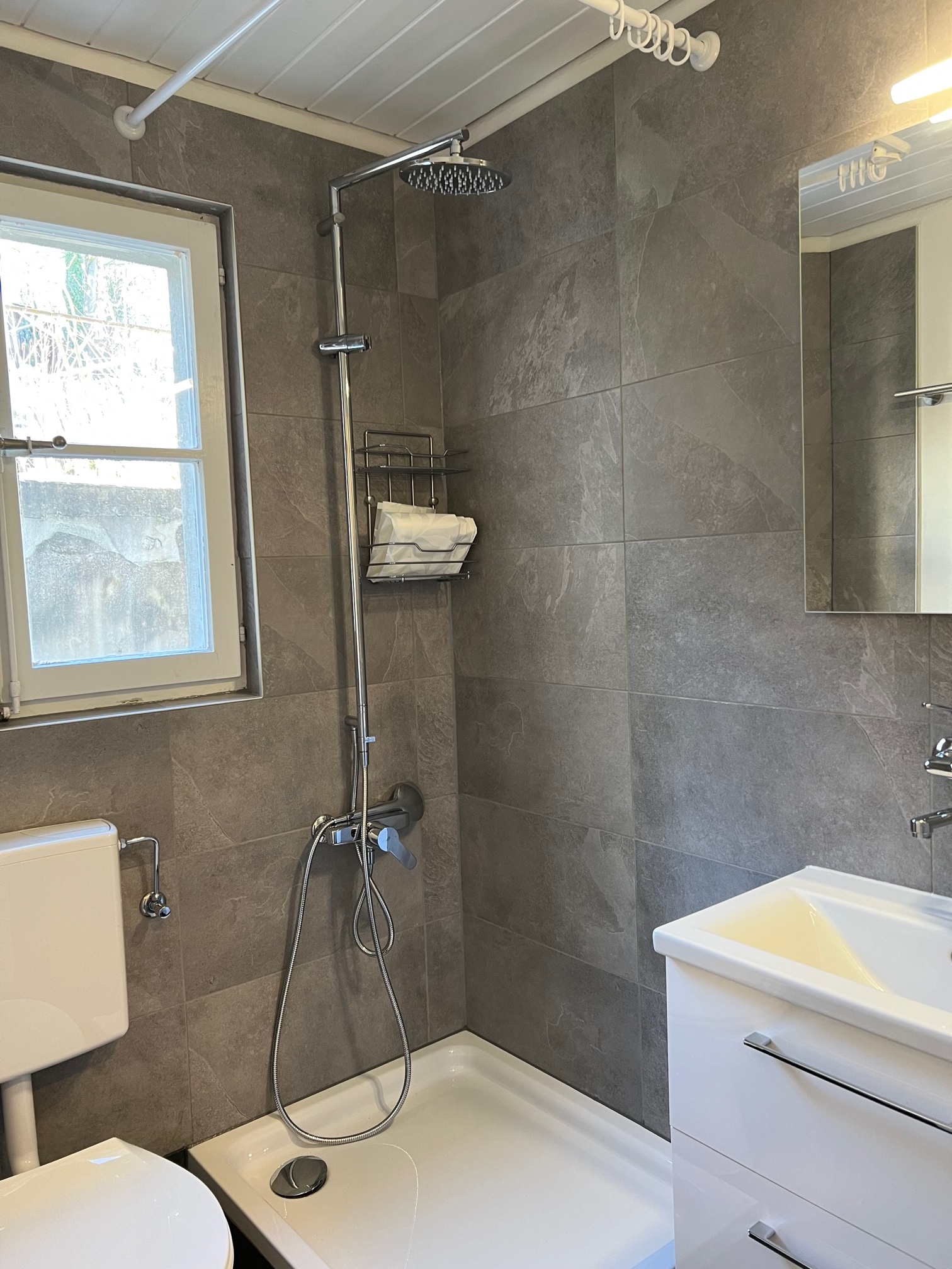 Modernes Badezimmer mit Dusche und Fenster
