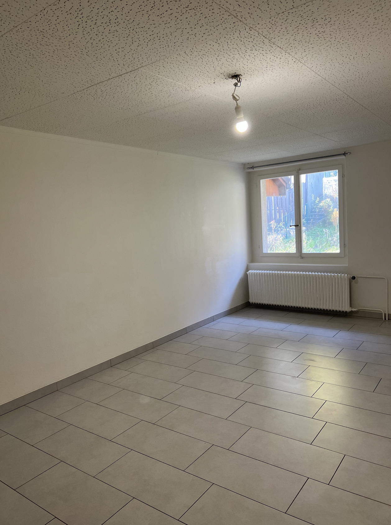 Leerer Raum mit Fliesenboden und Fenster
