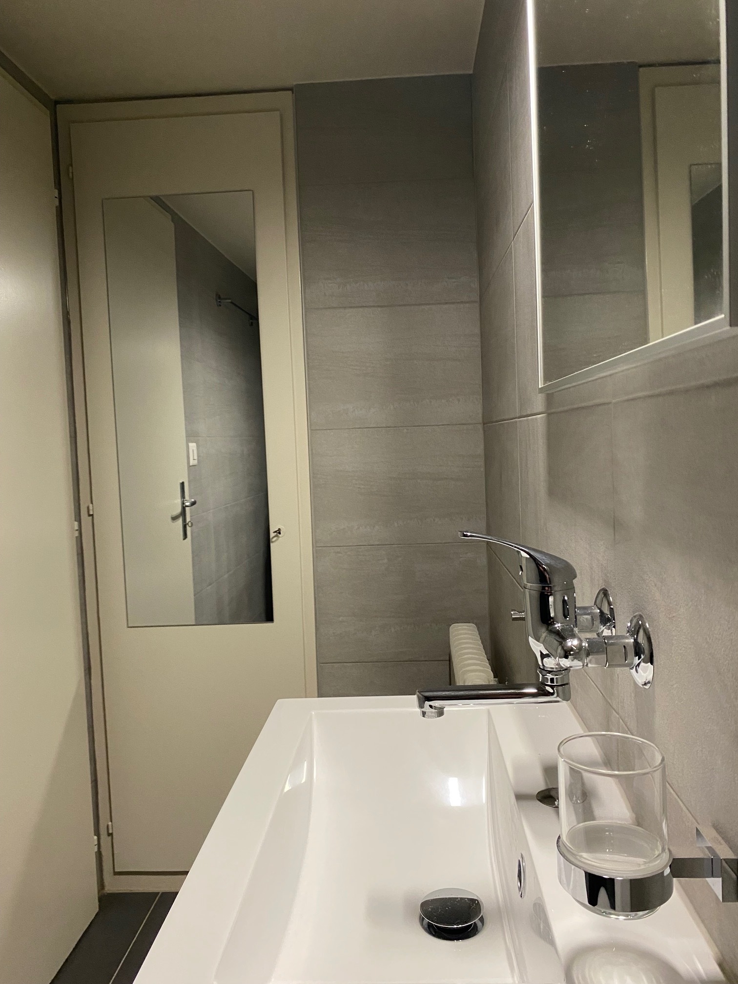 Kleines modernes Badezimmer mit Waschbecken und Spiegelschrank