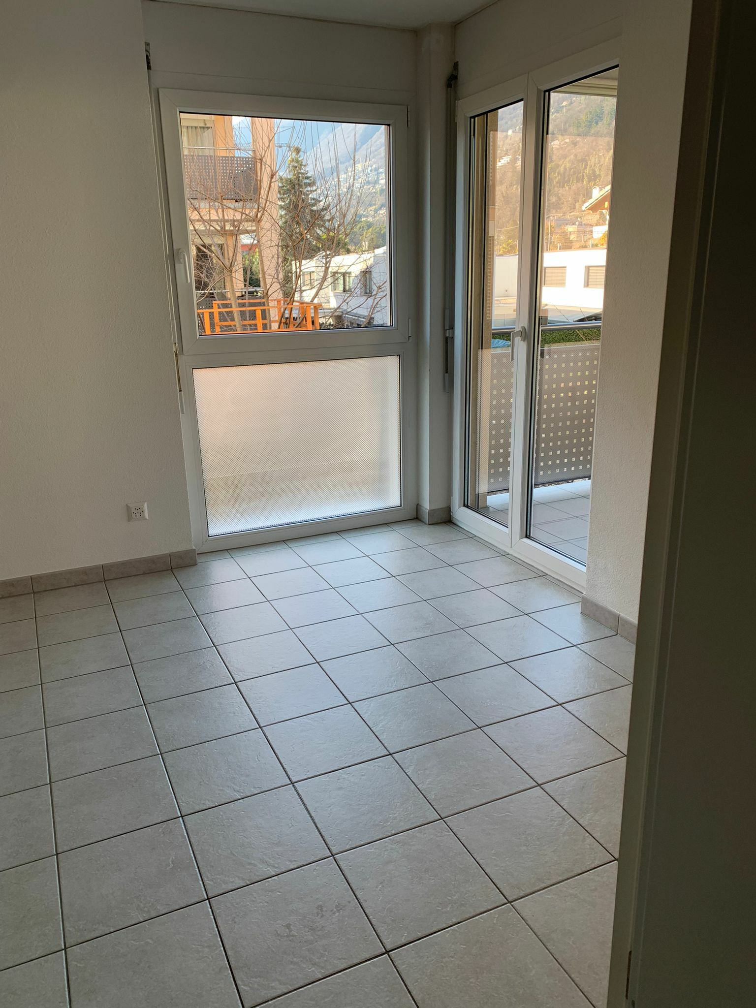 Leerer Wohnraum mit Balkonzugang