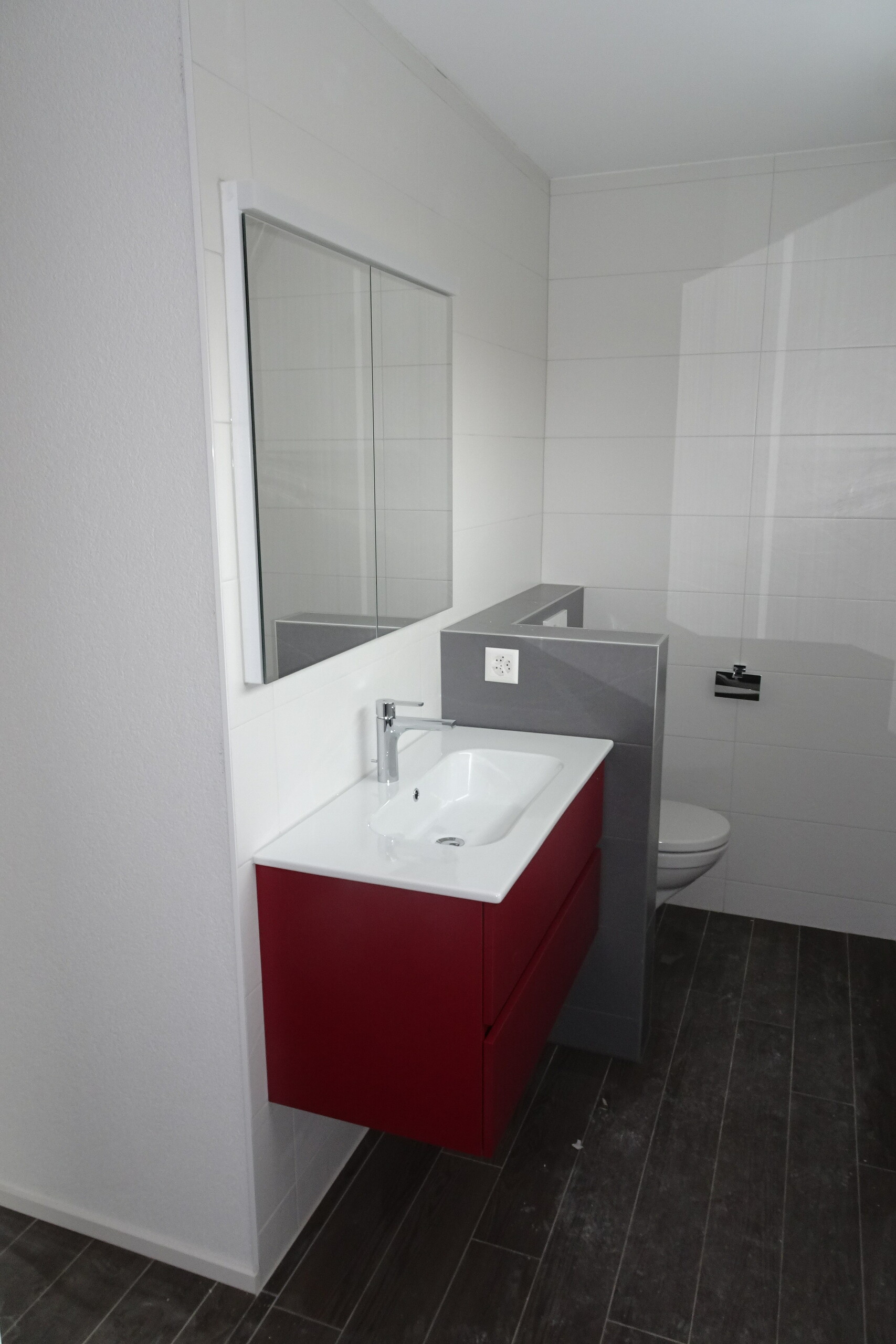 Modernes Badezimmer mit rotem Waschtischunterschrank