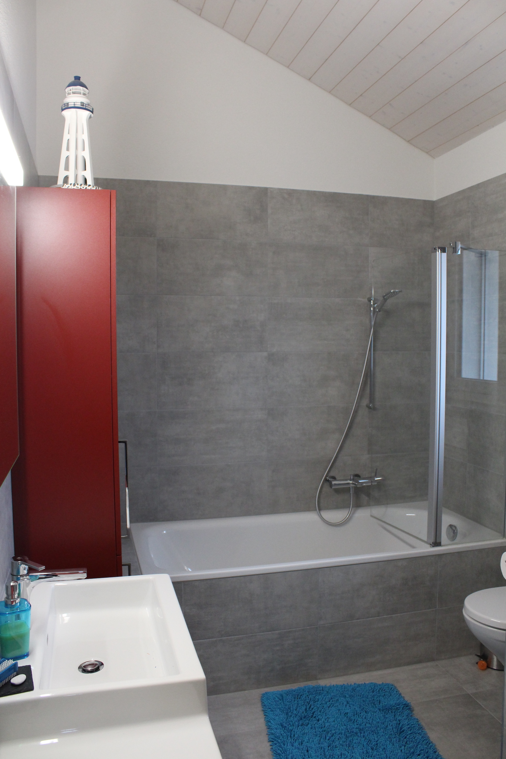 Modernes Badezimmer mit grauen Fliesen und Badewanne