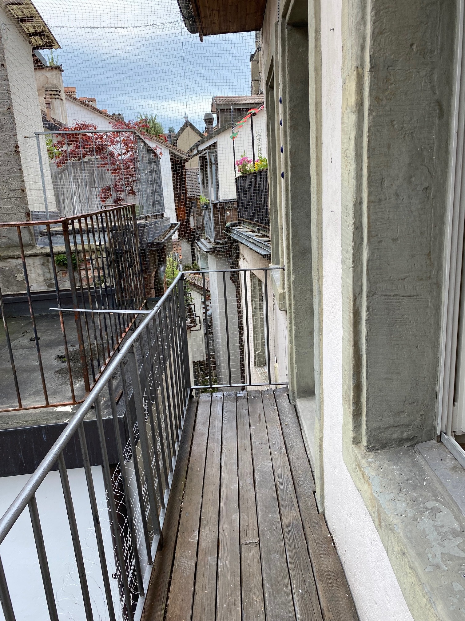 Schmale Dachterrasse oder Balkon zwischen Altbauten