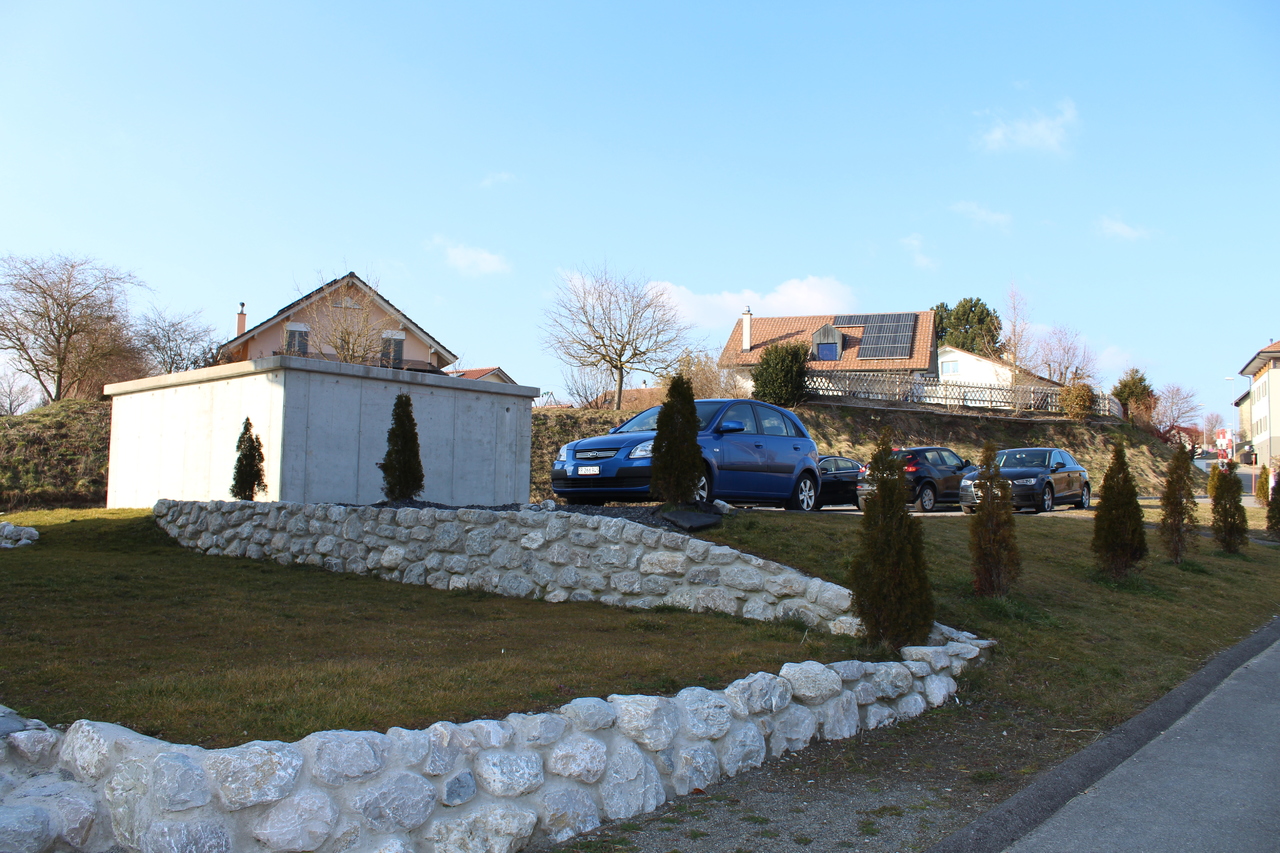 Außenansicht eines Wohnhauses mit Straßenrand und Parkbereich