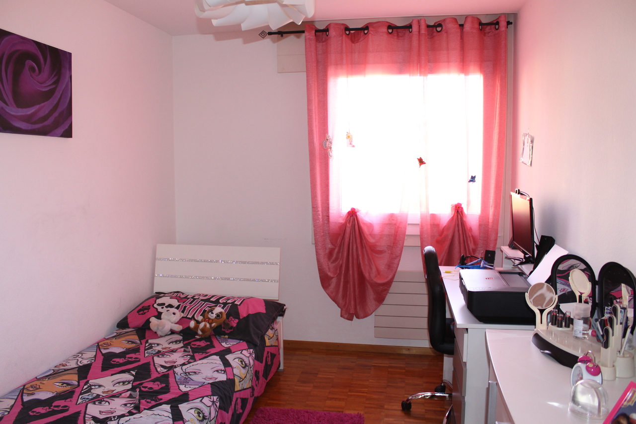 Jugendzimmer mit Bett, Schreibtisch und pinken Vorhängen