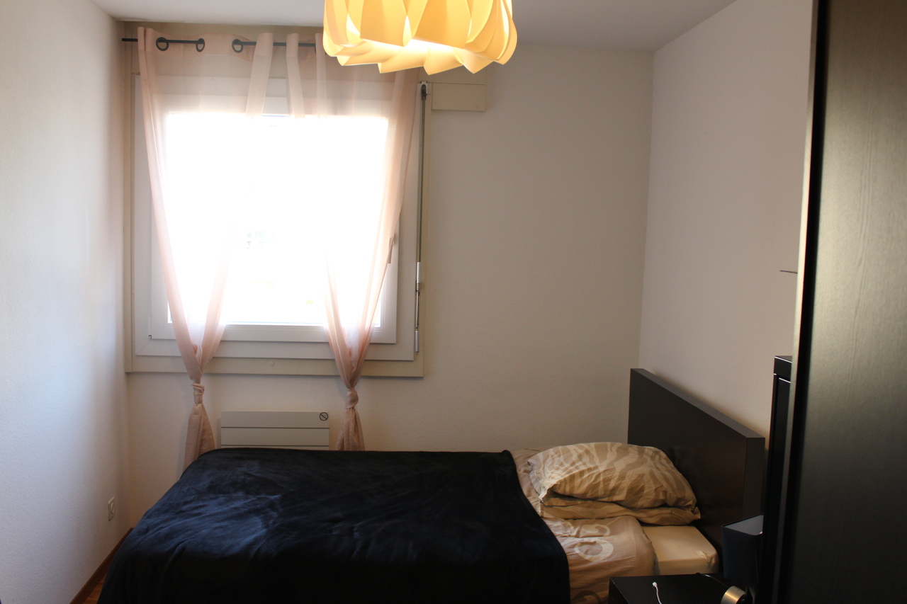 Kleines Schlafzimmer mit Fenster und Bett