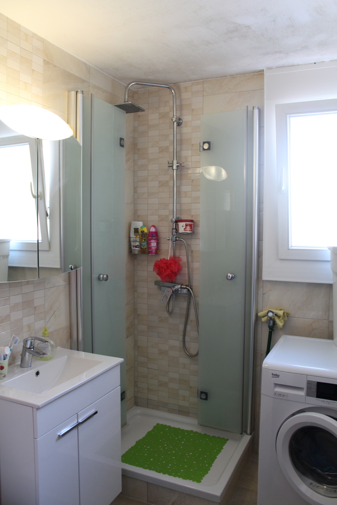 Badezimmer mit Dusche und Waschmaschine