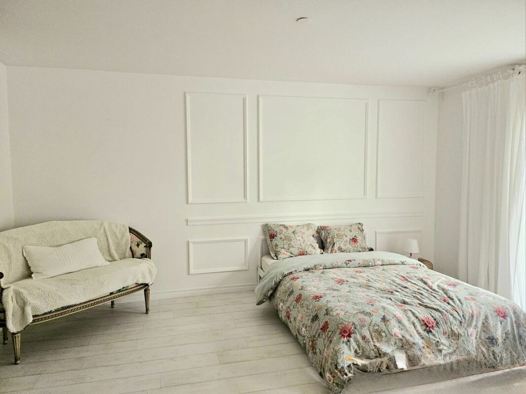 Helles Schlafzimmer mit floraler Bettwäsche