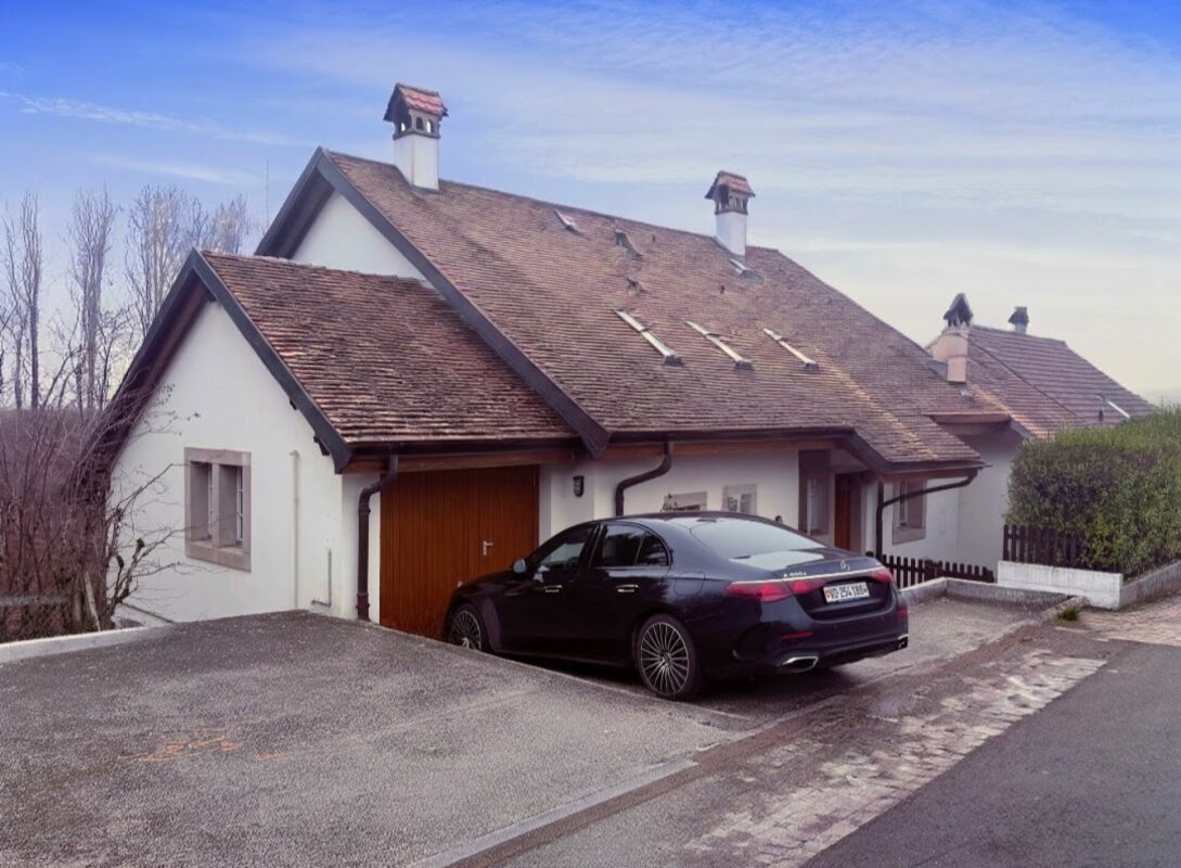 Wohnhaus mit steilem Satteldach und Auffahrt