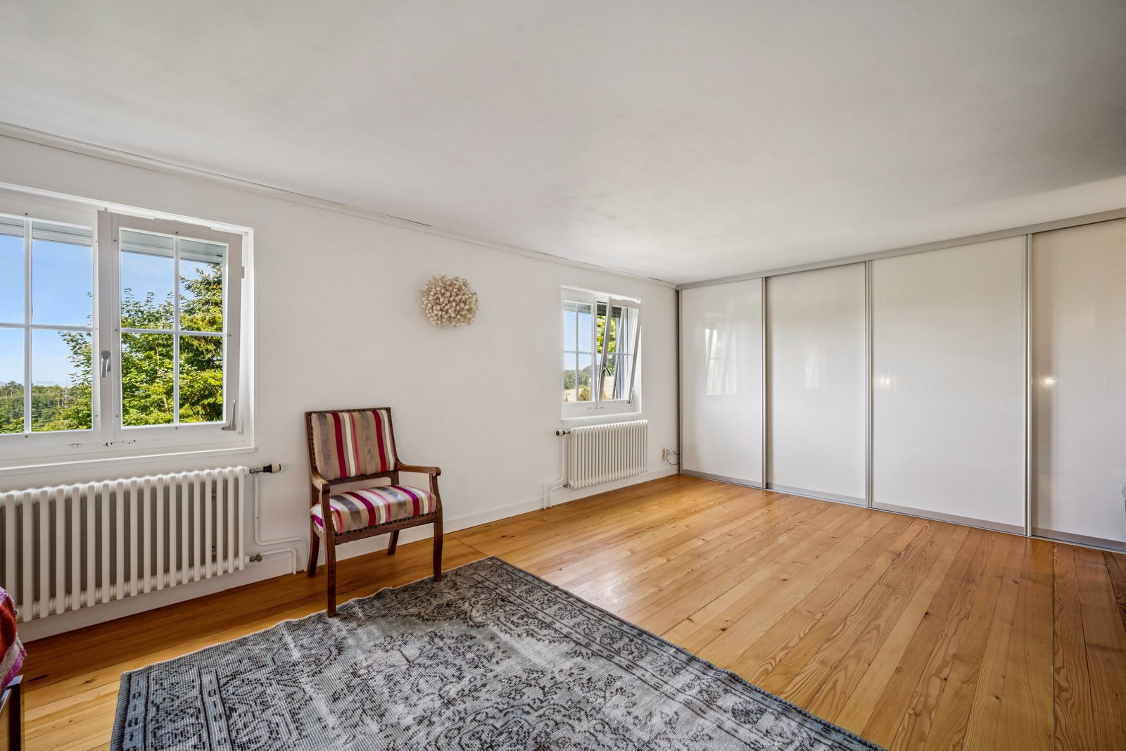 Helles Schlafzimmer mit Holzparkett und Einbauschrank