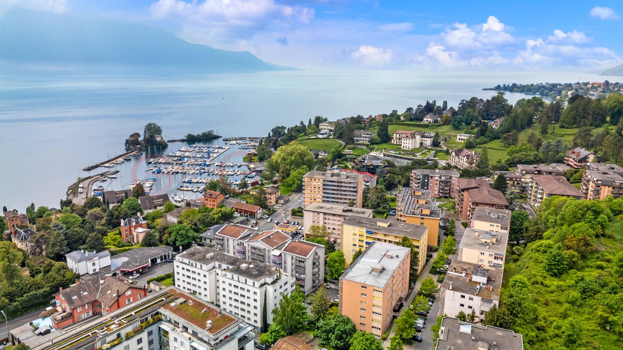 Luftaufnahme einer Seelandschaft mit Hafen und Wohngebiet