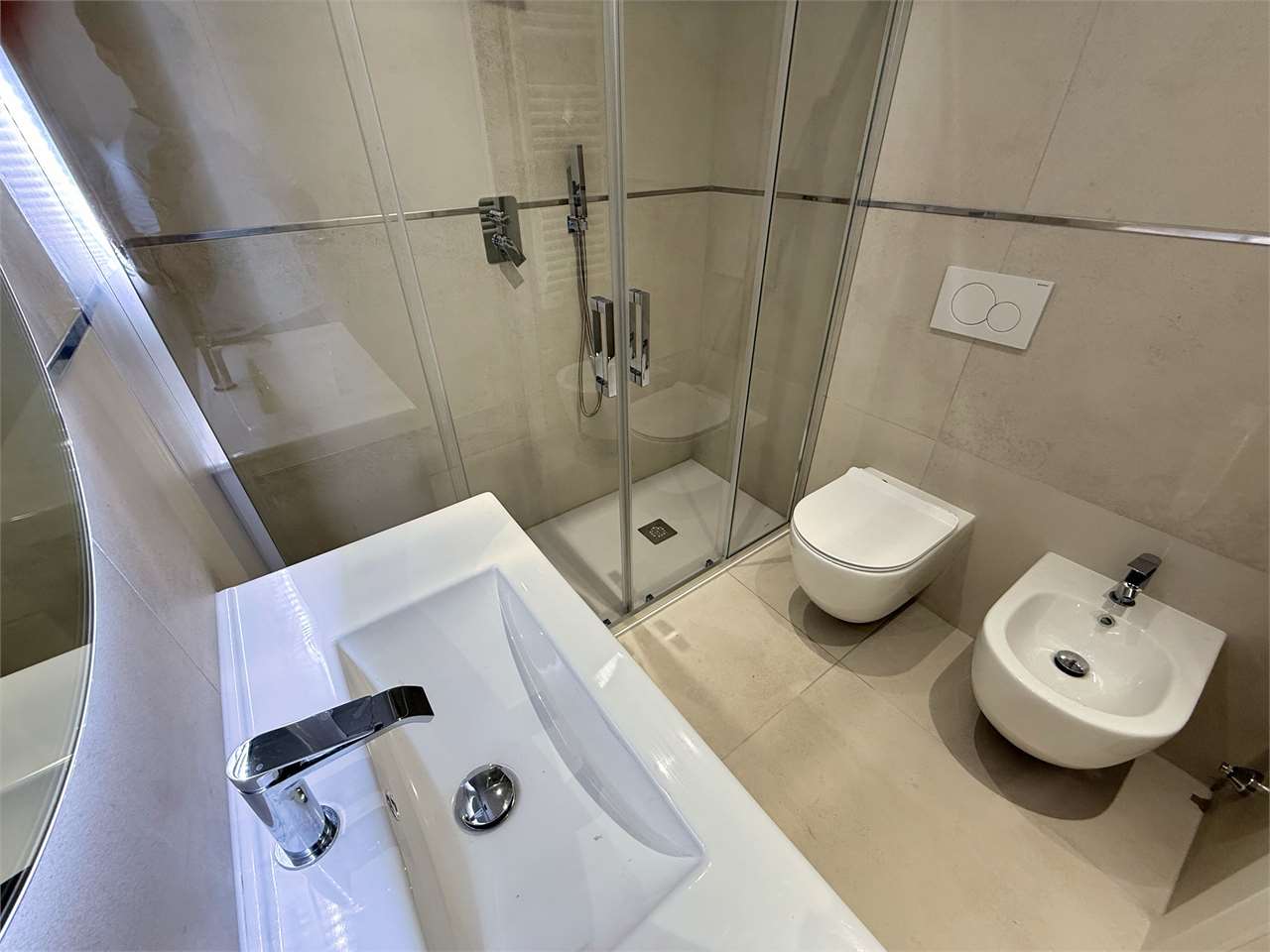 Modernes Badezimmer mit Glasdusche, Wanne, WC und Bidet