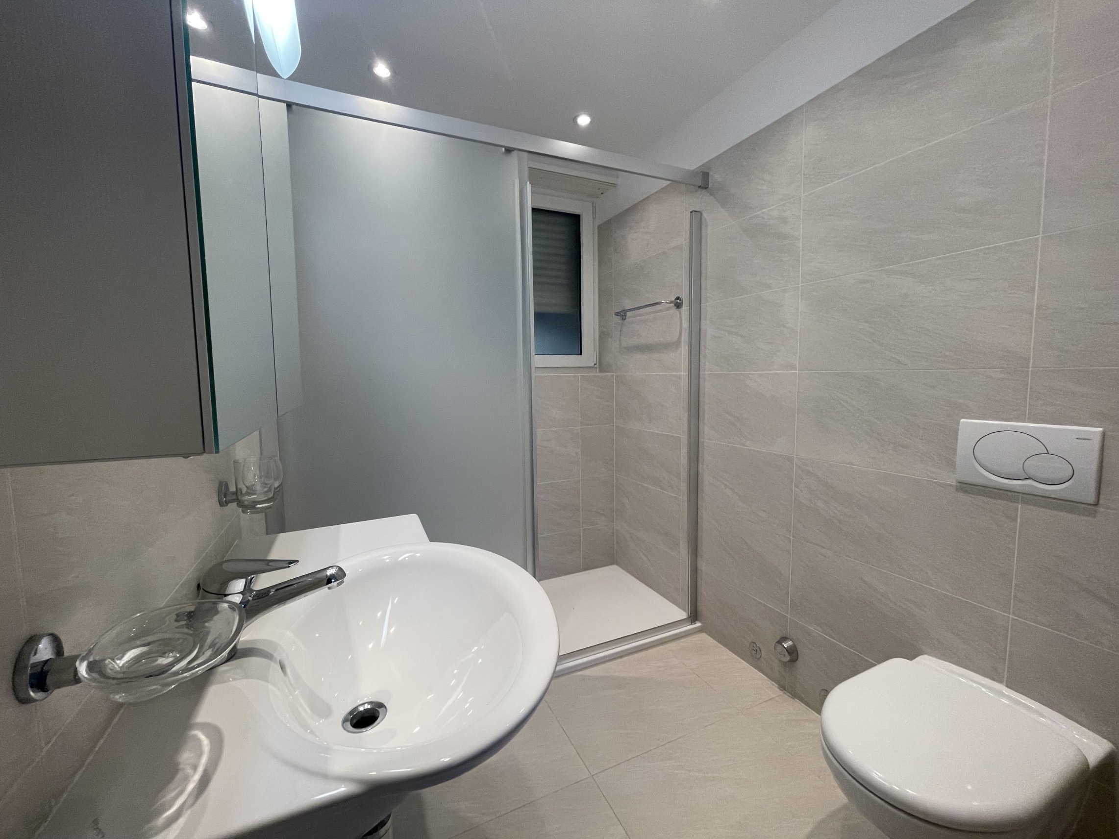 Modernes Badezimmer mit Dusche und Wand-WC