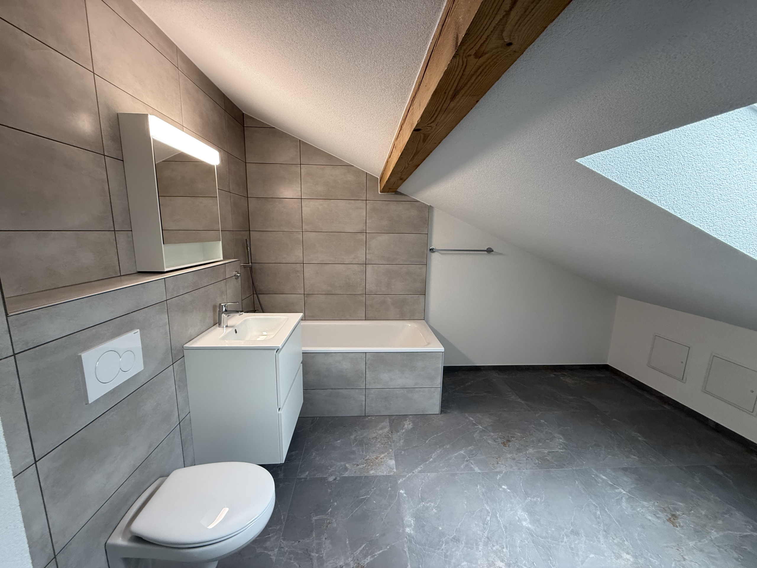 Modernes Dachgeschoss-Badezimmer mit Badewanne und Dachschräge
