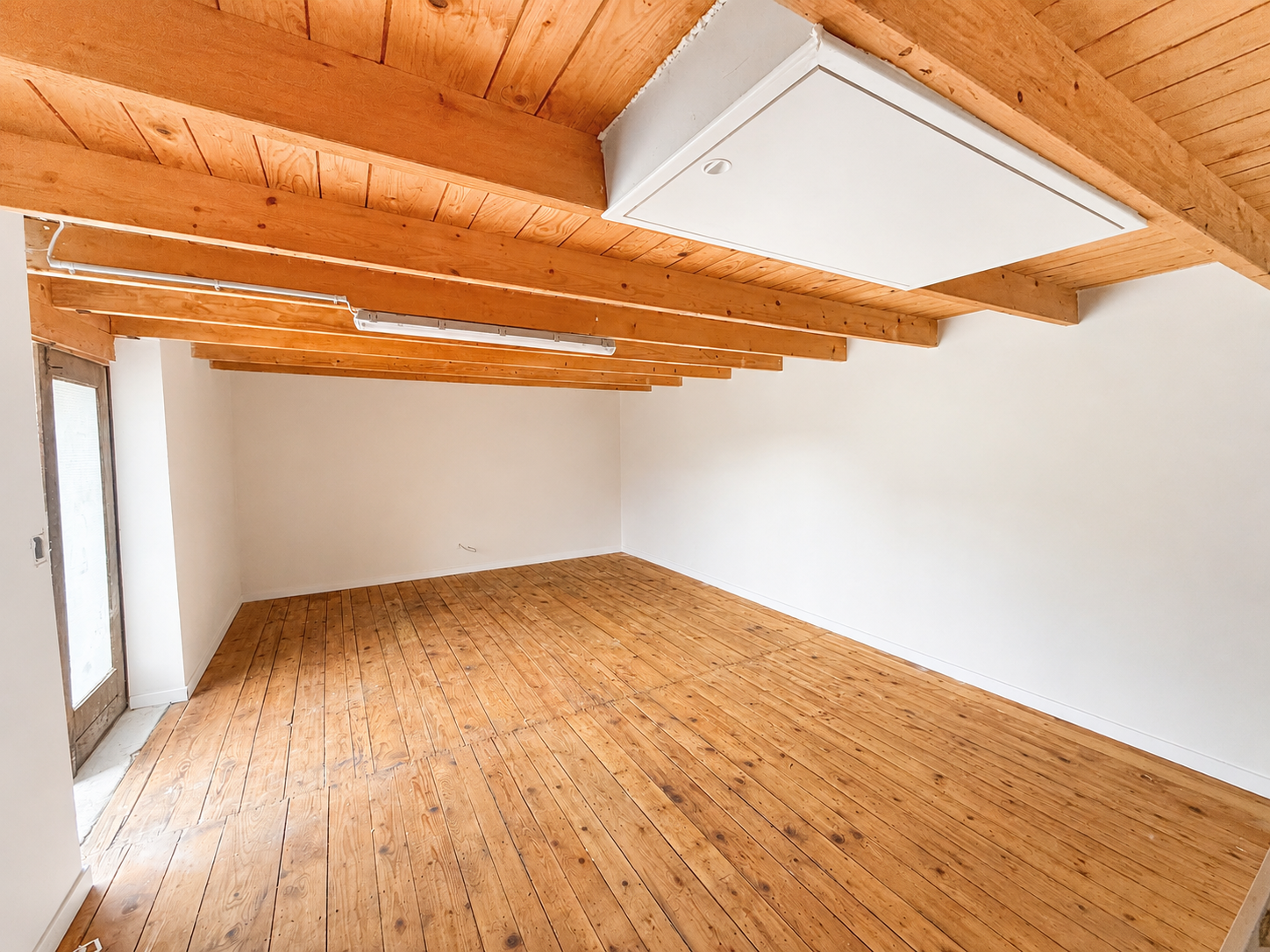 Leerer Dachgeschossraum mit Holzdecke und Holzfußboden