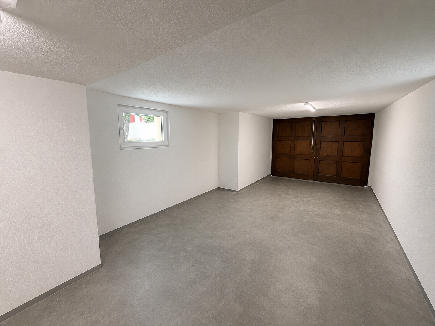 Innenraum mit Betonboden und Holztor