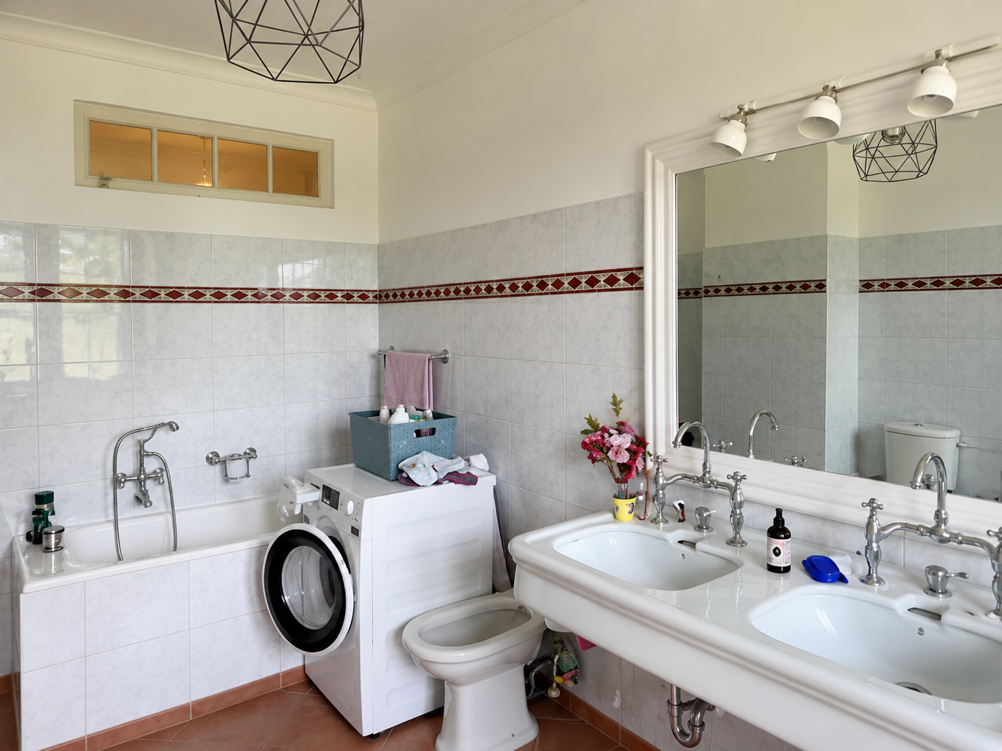 Badezimmer mit Badewanne, Doppelwaschbecken und Waschmaschine