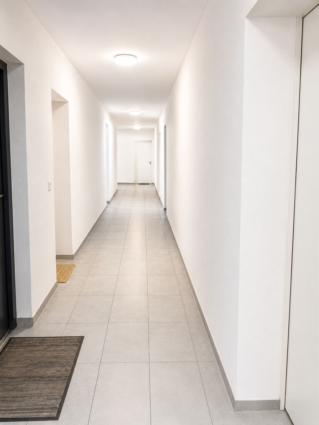Heller, schmaler Flur mit Fliesenboden