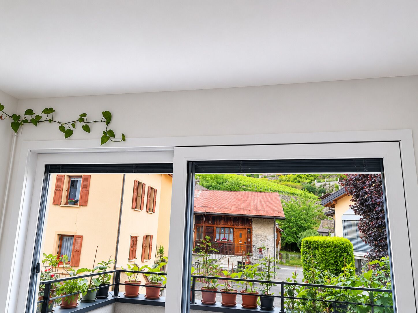 Blick vom Innenraum auf einen Balkon und die Nachbargebäude