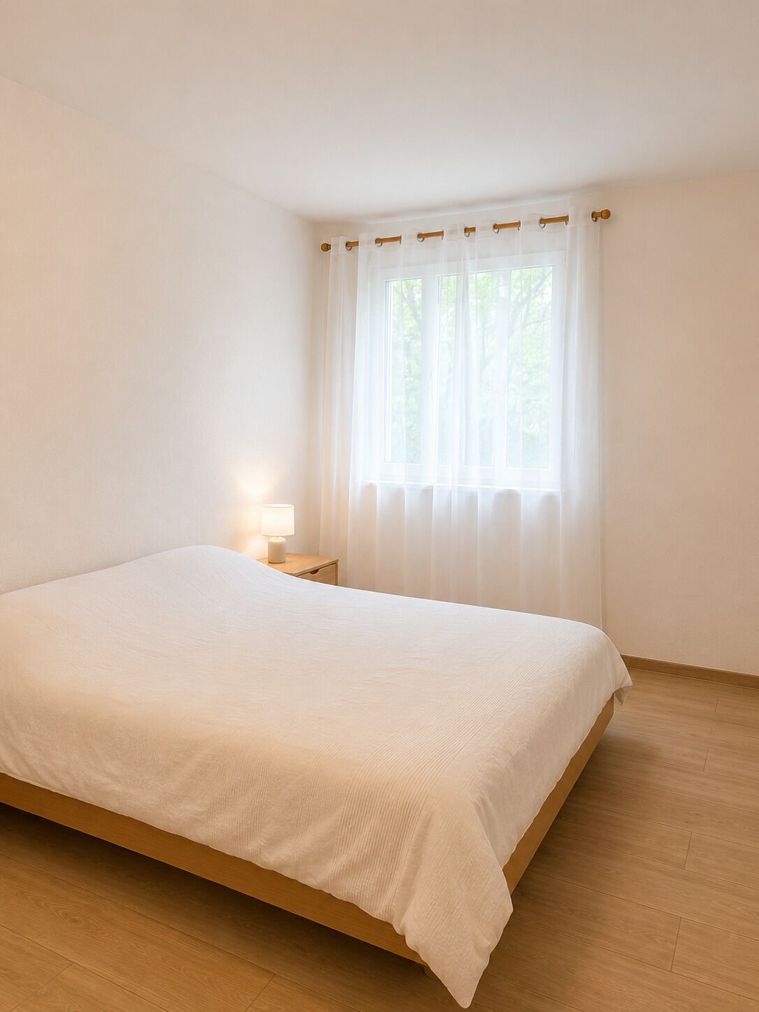 Helles Schlafzimmer mit schlichtem Doppelbett