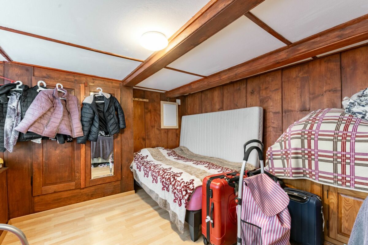 Kleines holzverkleidetes Schlafzimmer mit Gepäck