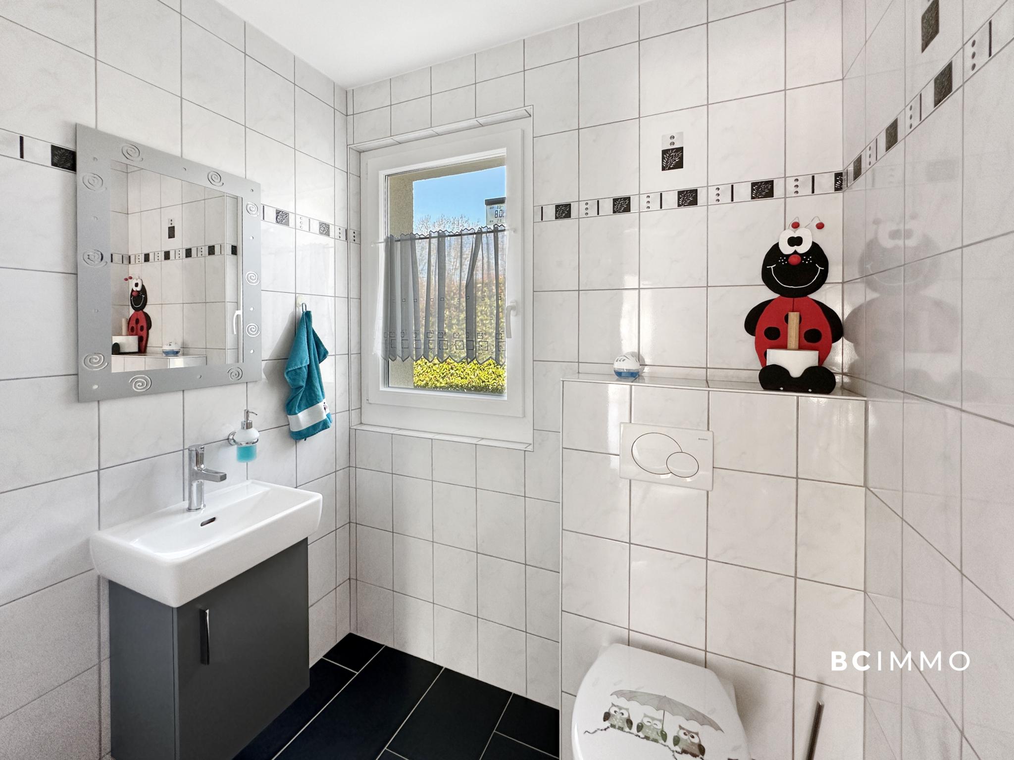 Kleines modernes Gäste-WC mit Fenster und Wandfliesen
