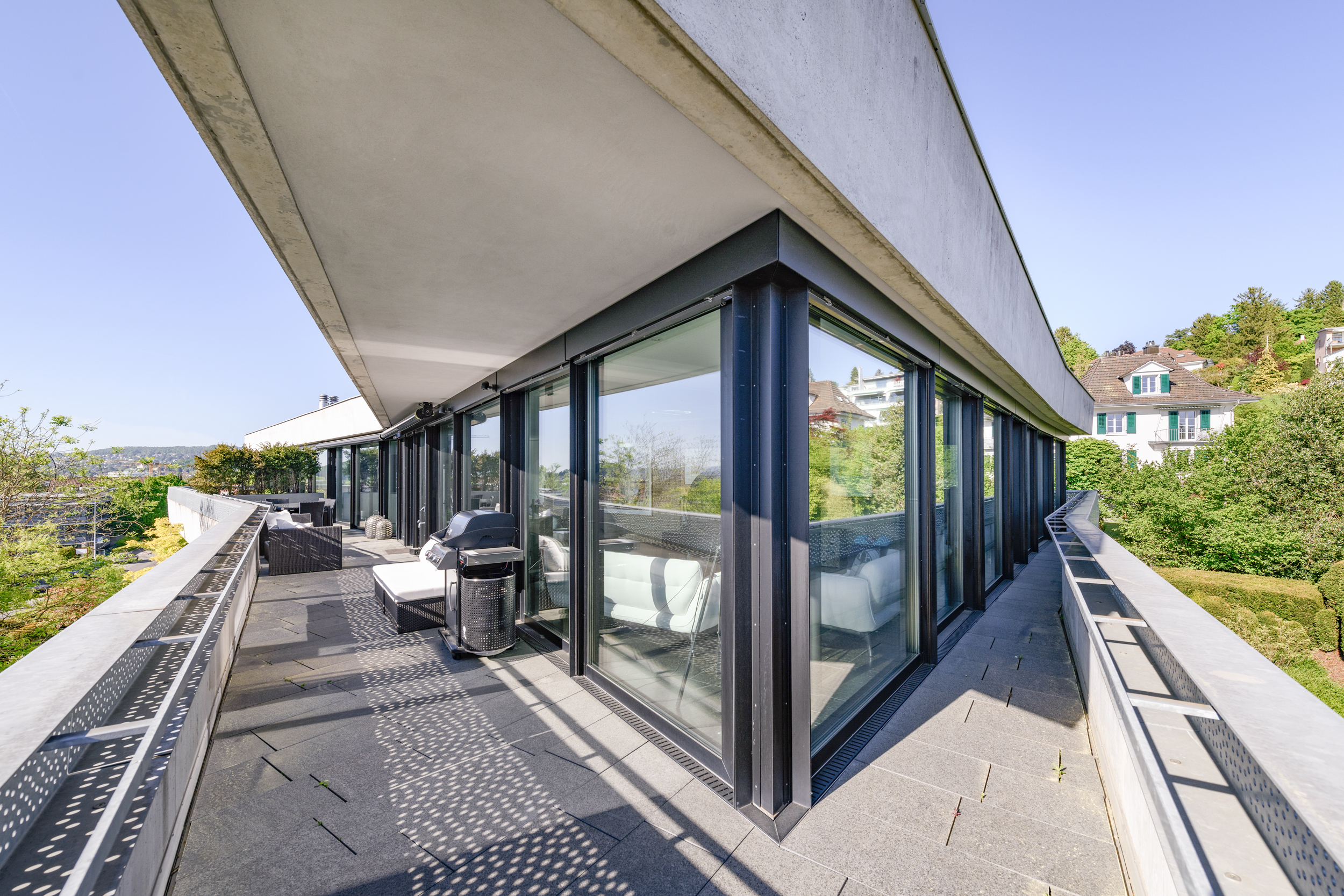 Moderne Dachterrasse mit Glasfront und Panoramablick