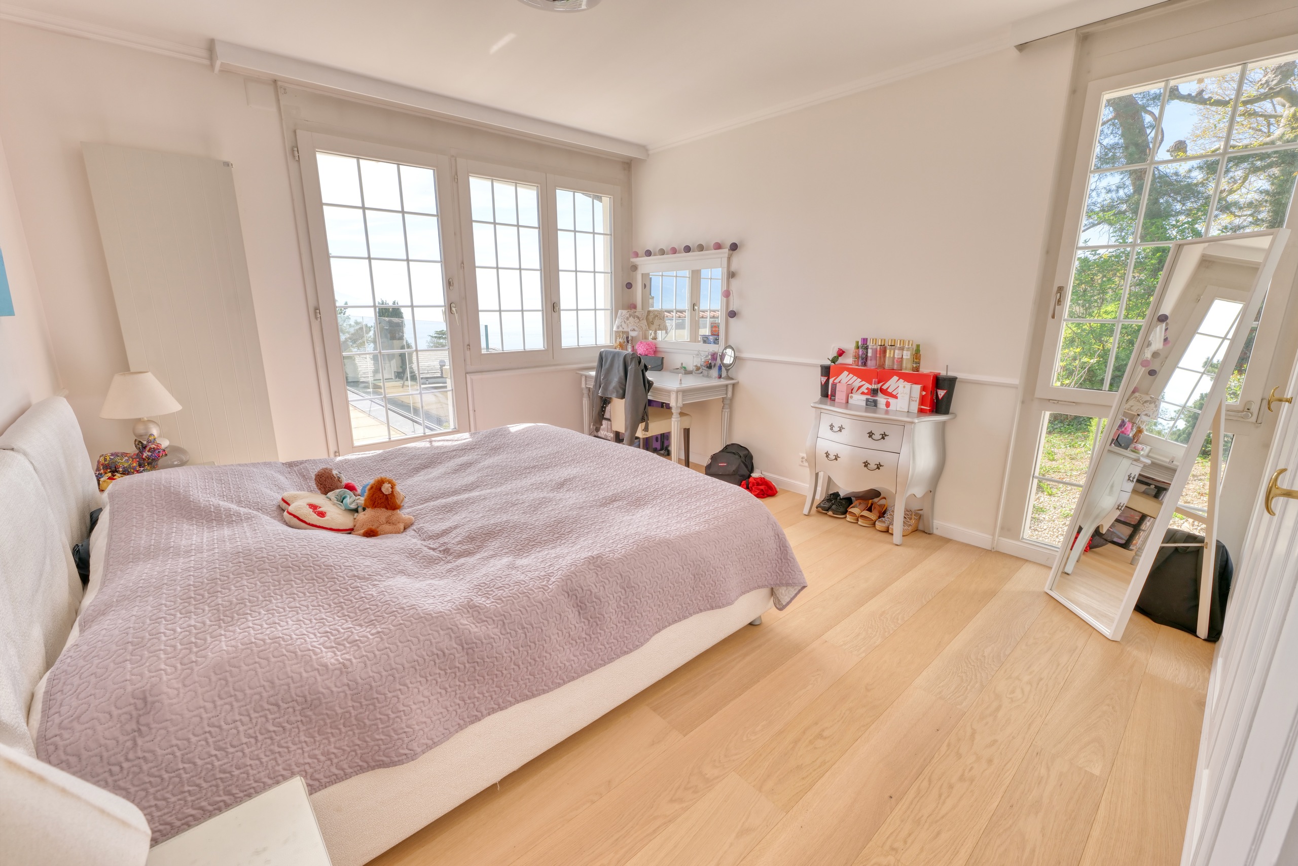 Helles Schlafzimmer mit großen Fenstern und Balkonzugang